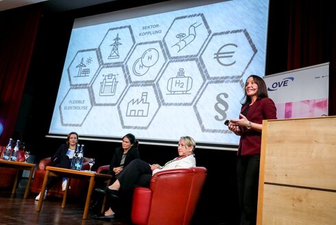 Diskussionspanel mit einer Frau als Rednerin im Vordergrund