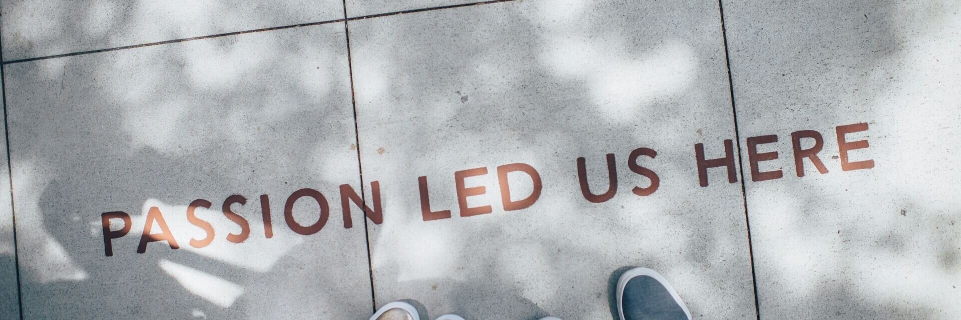 Füße auf Beton mit Aufschrift Passion Led Us Here