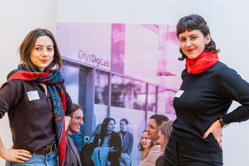 Zwei Studentinnen vor einem Roll-up